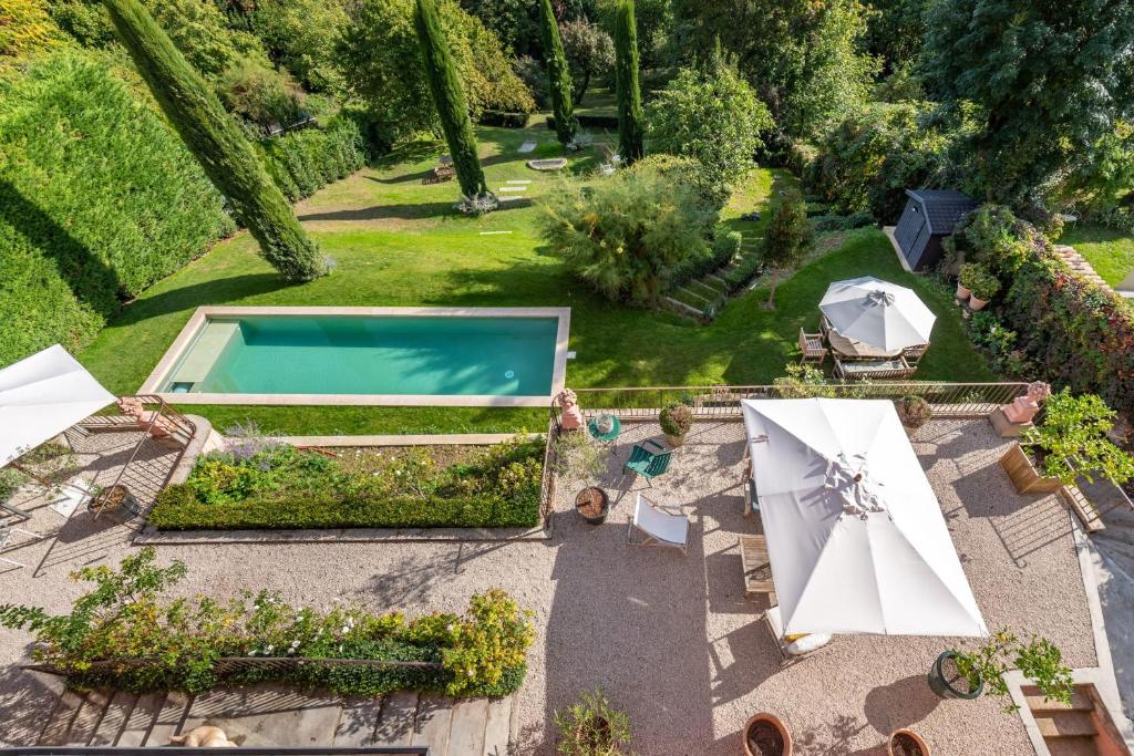 - une vue aérienne sur un jardin avec une piscine et des parasols dans l'établissement La vue - Charming house with a pool garden and amazing view, à La Mulatière