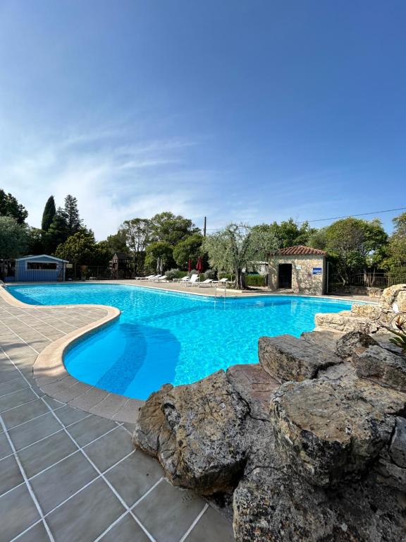 a swimming pool with blue water and rocks at La Lune De Mougins - Hotel & Spa in Mougins