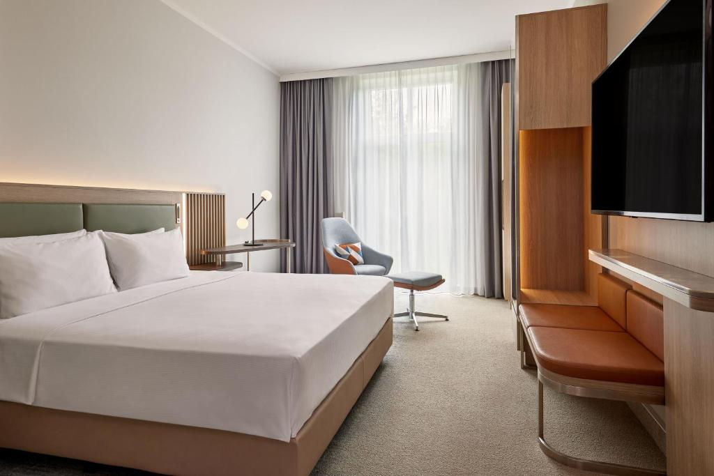 a hotel room with a bed and a television at Courtyard by Marriott Schwerin in Schwerin