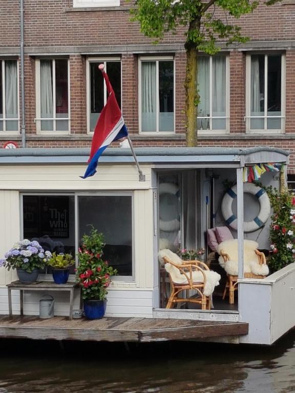 een huis met een vlag op de achterkant van een boot bij Pantheos Top Houseboat in Amsterdam