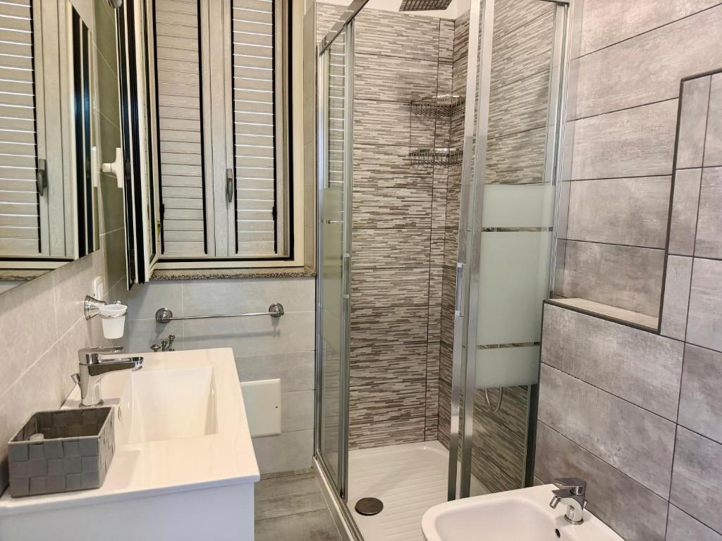 La salle de bains est pourvue d'une douche, d'un lavabo et de toilettes. dans l'établissement Affacciati sulle Eolie Appartamenti sul Lungomare Patti Marina, à Patti