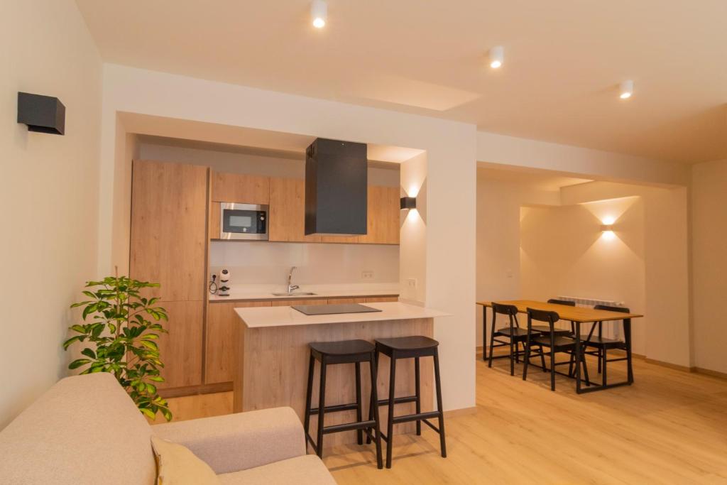 a kitchen and living room with a counter and stools at Apartamento Holidea La Primera del Sardinero in Santander