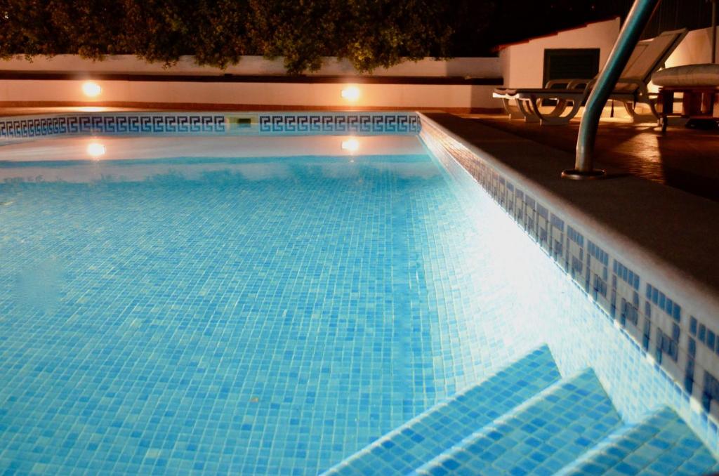 a large swimming pool with blue tiles on it at Villa ELTAEL - Miguel House - Warm Pool until 1 November - Facilities for disabled guests in Manta Rota