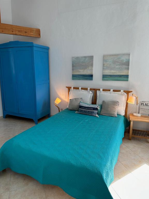 - une chambre avec un lit bleu et une commode bleue dans l'établissement L'air du largeMaison 4ch, à Bourcefranc