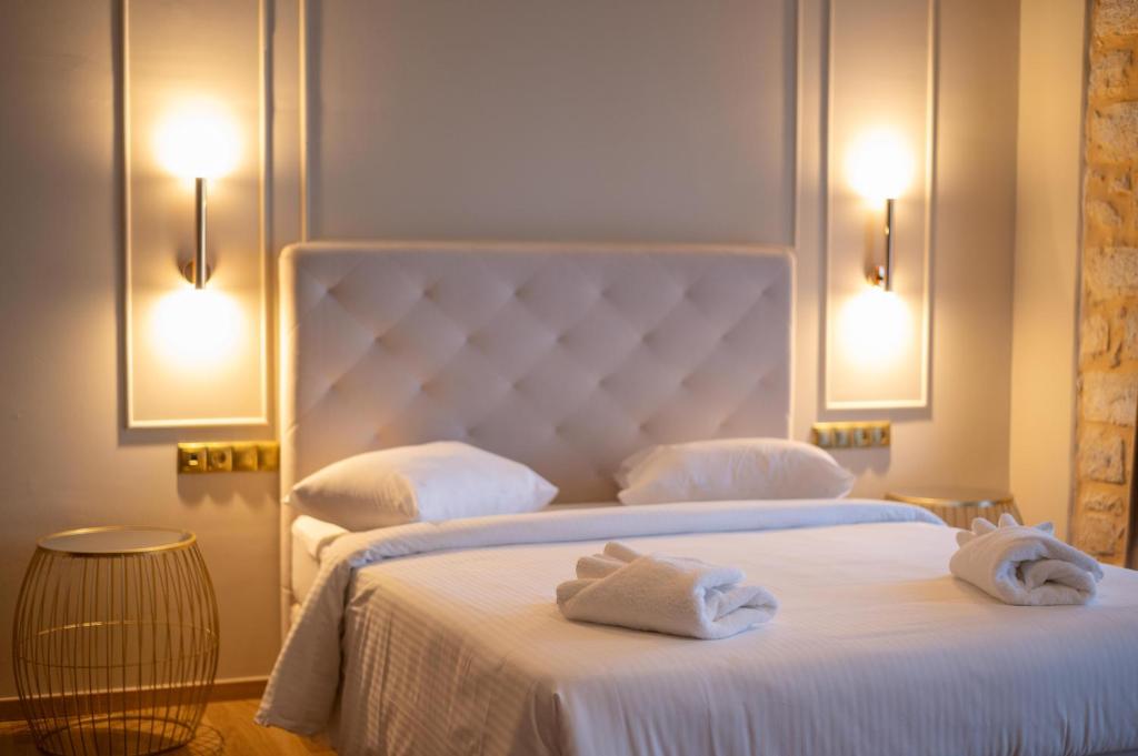 Dos camas en una habitación de hotel con toallas. en L Suites The Writer's House, en Gythio