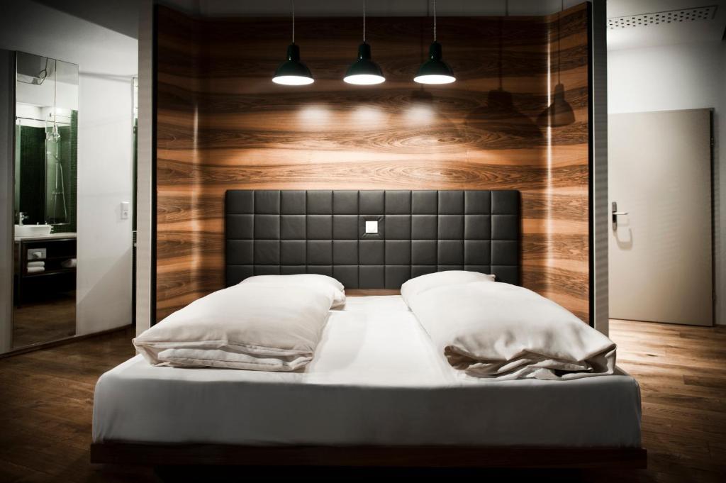 a bed in a room with a wooden wall at Hotel Daniel Vienna - Smart Lifestyle Near City Centre in Vienna