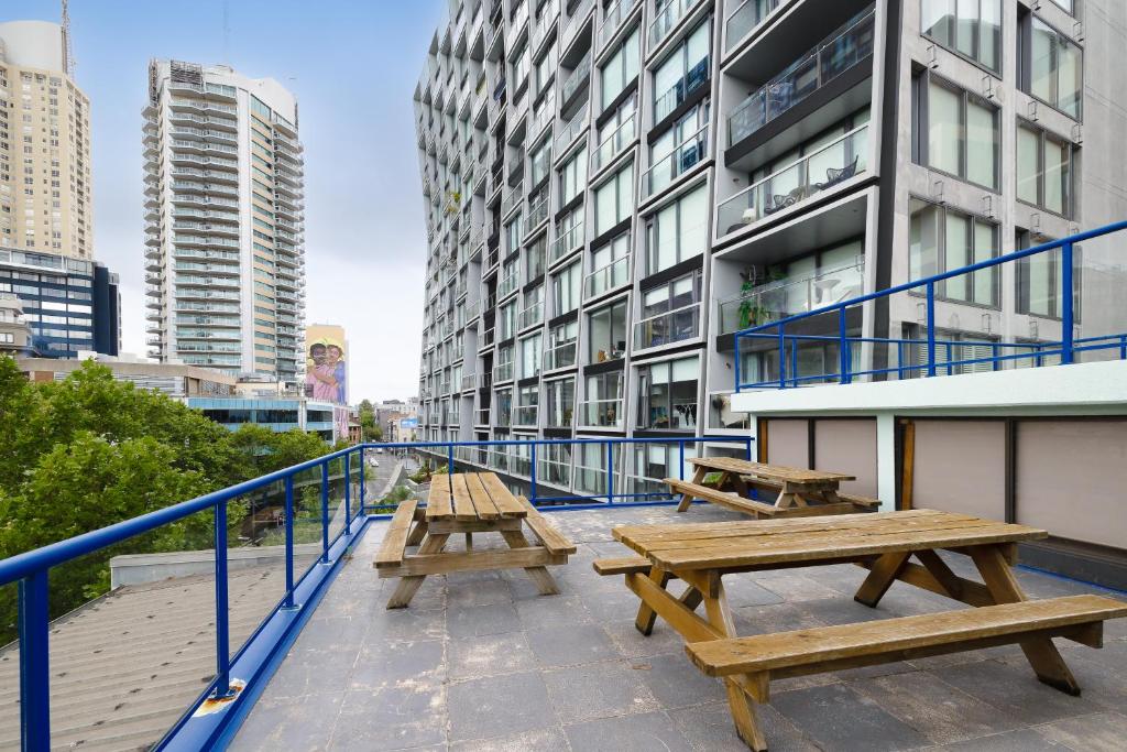 tres mesas de picnic en el techo de un edificio en Trademark Hostel Sydney en Sídney