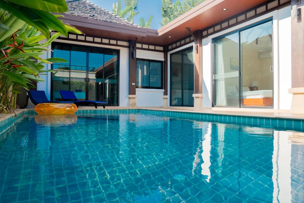 a swimming pool in front of a house at Near beach 3bedroom pool villa.（Rawai VIP B6） in Rawai Beach