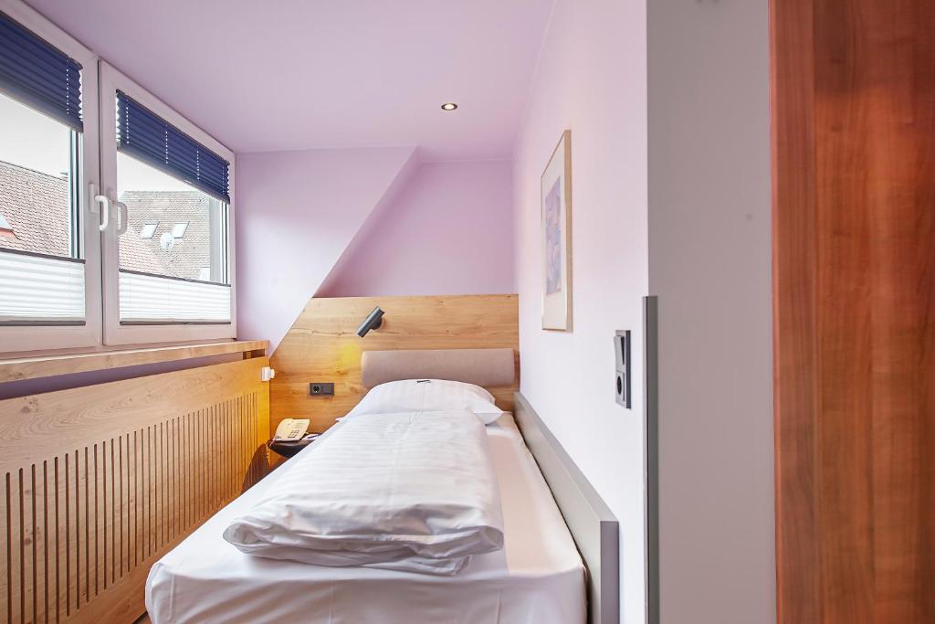 a small room with a bed in a room at Hotel am Jakobsmarkt in Nuremberg