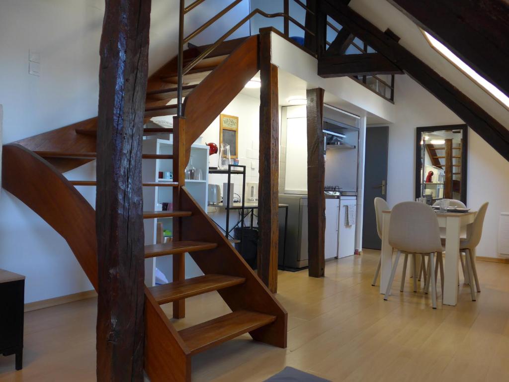 - un escalier en bois dans un salon avec une cuisine dans l'établissement Studio 38m2 centre-ville, à Bourges