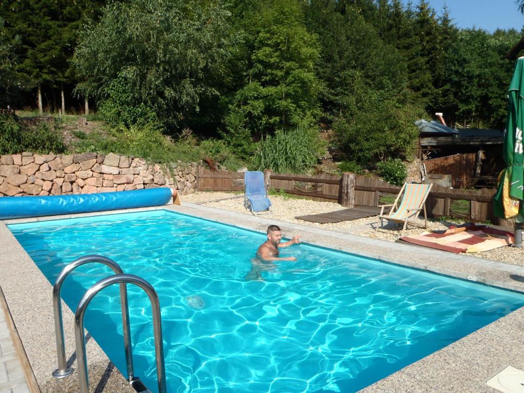 een jongetje in een zwembad in een tuin bij Penzion Javorský mlýn in Lázně Bělohrad