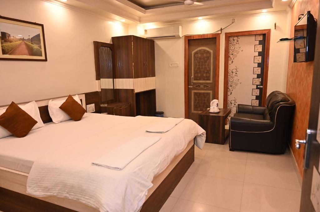 ein Schlafzimmer mit einem Bett und einem Stuhl darin in der Unterkunft HOTEL GITANJALI in Māldah
