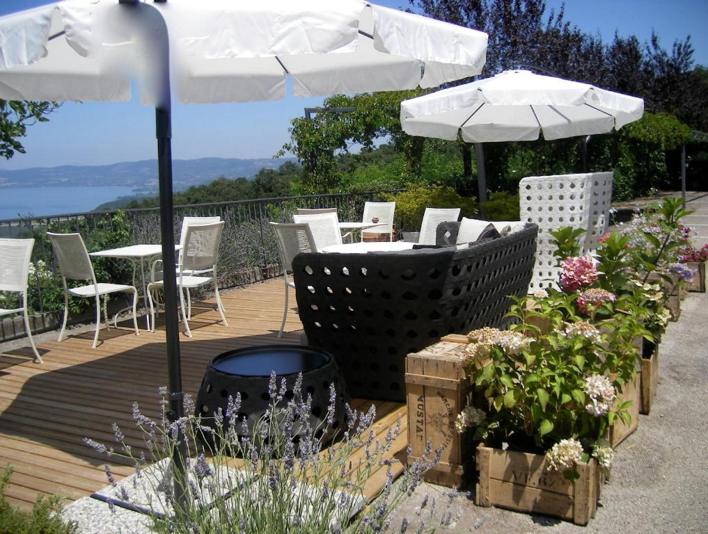a deck with a table and chairs and an umbrella at Il Caminetto Montefiascone in Montefiascone