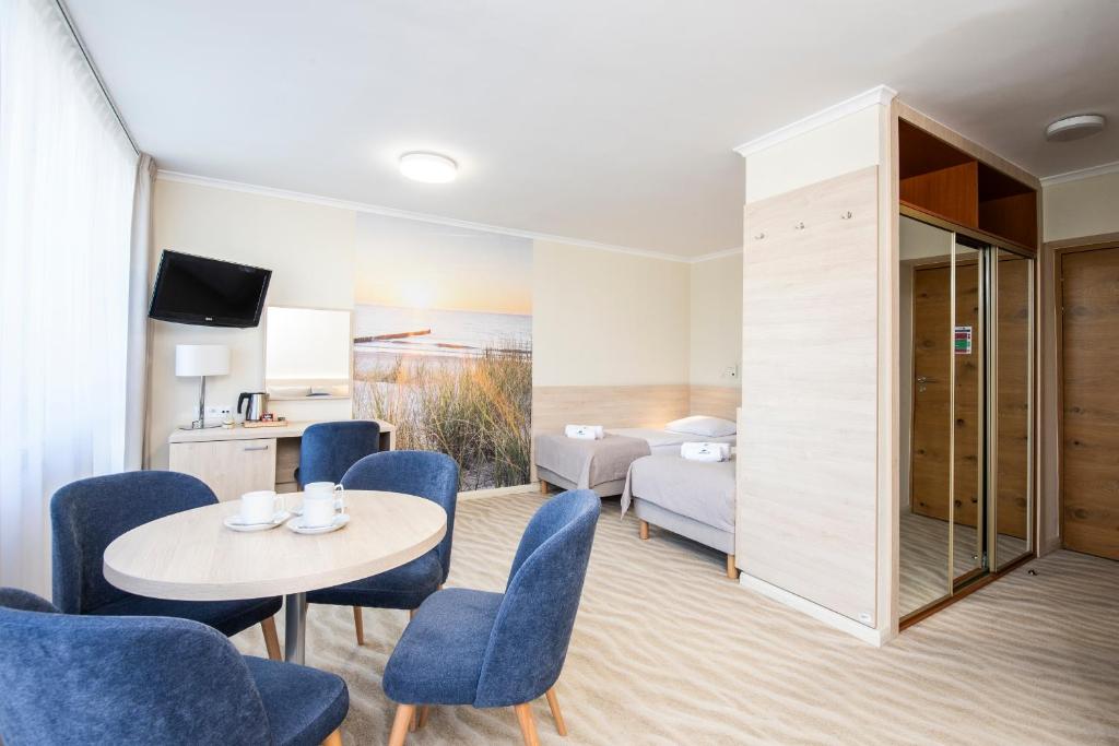 um quarto de hotel com uma cama, uma mesa e cadeiras em Interferie Cechsztyn em Ustronie Morskie