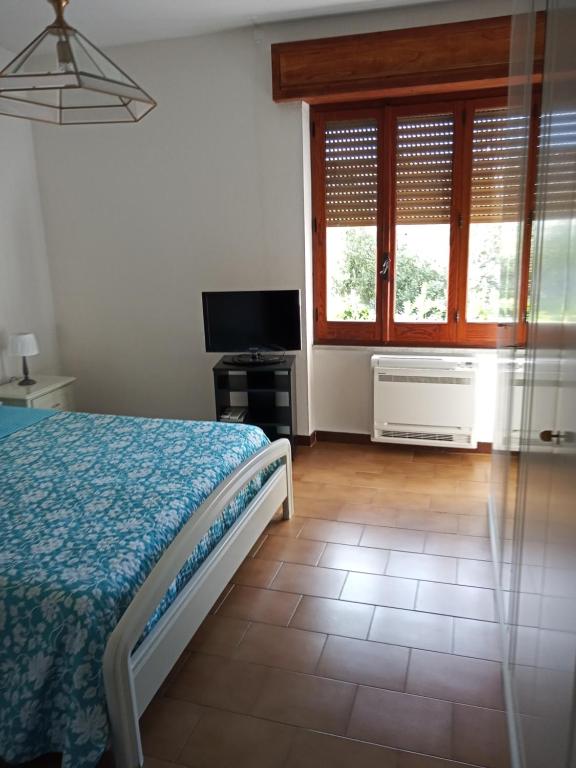 a bedroom with a bed and a tv and windows at Casa Lino in Monserrato