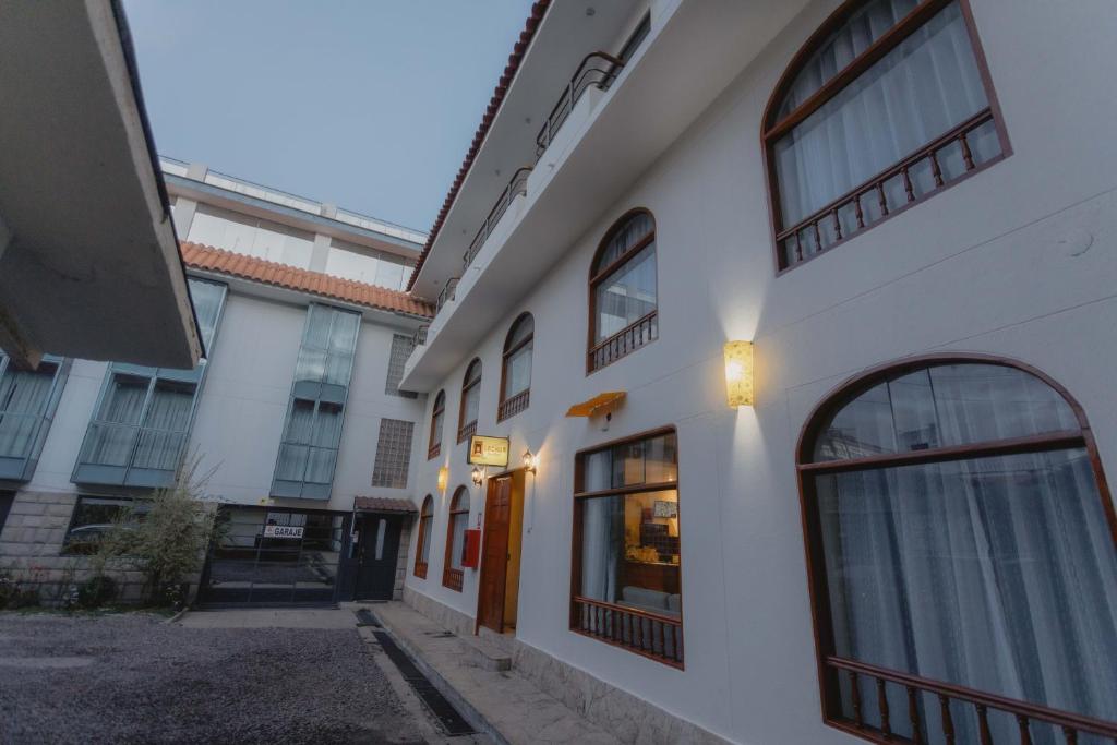 a white building with windows and a door at Quechua ApartHotel in Cusco