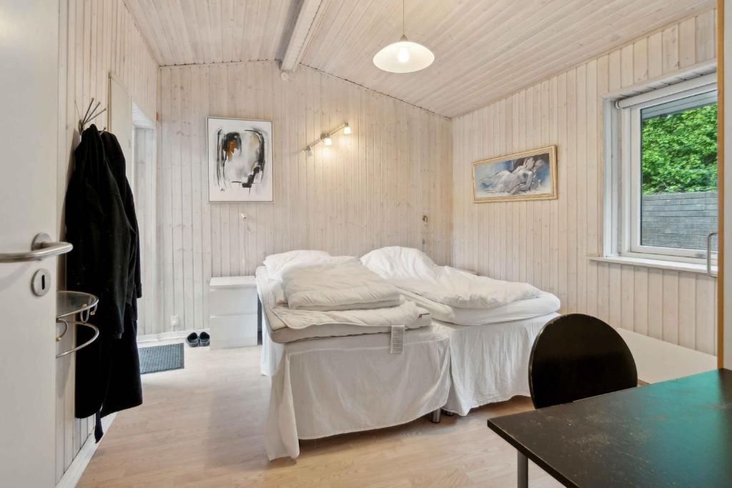 Classic Summer House 200 Meters From The Water, في Børkop: غرفة فيها سرير وطاولة فيها