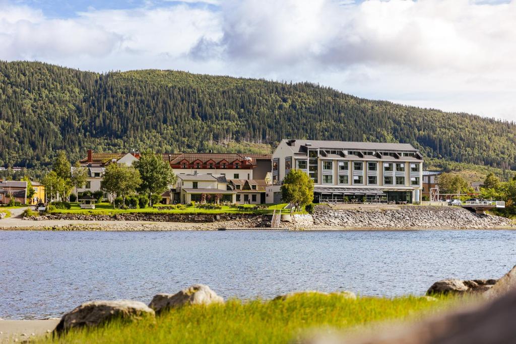 a large building next to a large body of water at Fru Haugans Hotel in Mosjøen