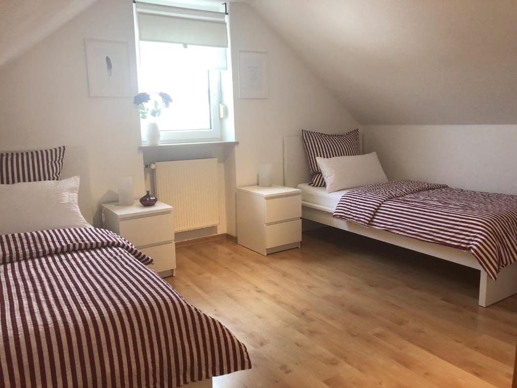 Cette chambre comprend 2 lits et une fenêtre. dans l'établissement Ferienwohnung Am Kreuzberg für 2 Personen, à Medlingen