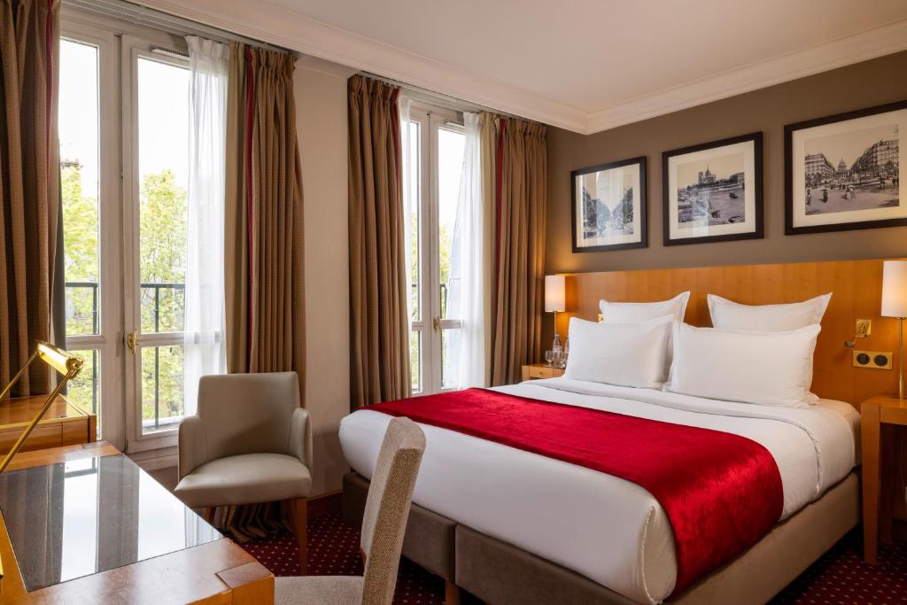 een hotelkamer met een groot bed en een raam bij Royal Saint Michel in Parijs