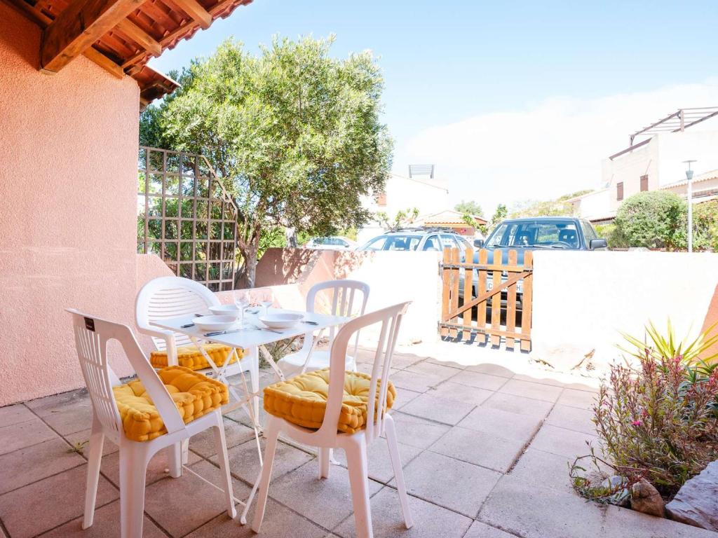 une table blanche et des chaises sur une terrasse dans l'établissement Charmant pavillon studio mezzanine avec piscine, terrasse, 4 couchages, animaux OK, parking privé - FR-1-409-52, à Gruissan
