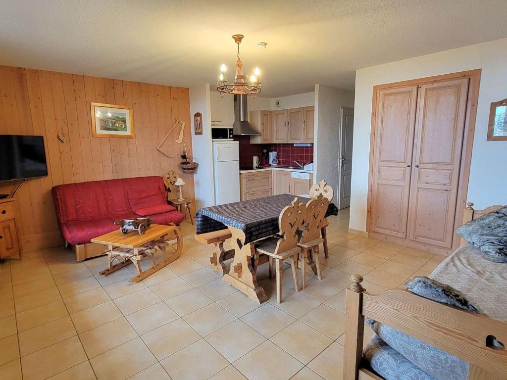 sala de estar con mesa y sofá rojo en Appartement Saint-Michel-de-Chaillol, 2 pièces, 6 personnes - FR-1-393-32, en Saint-Michel-de-Chaillol