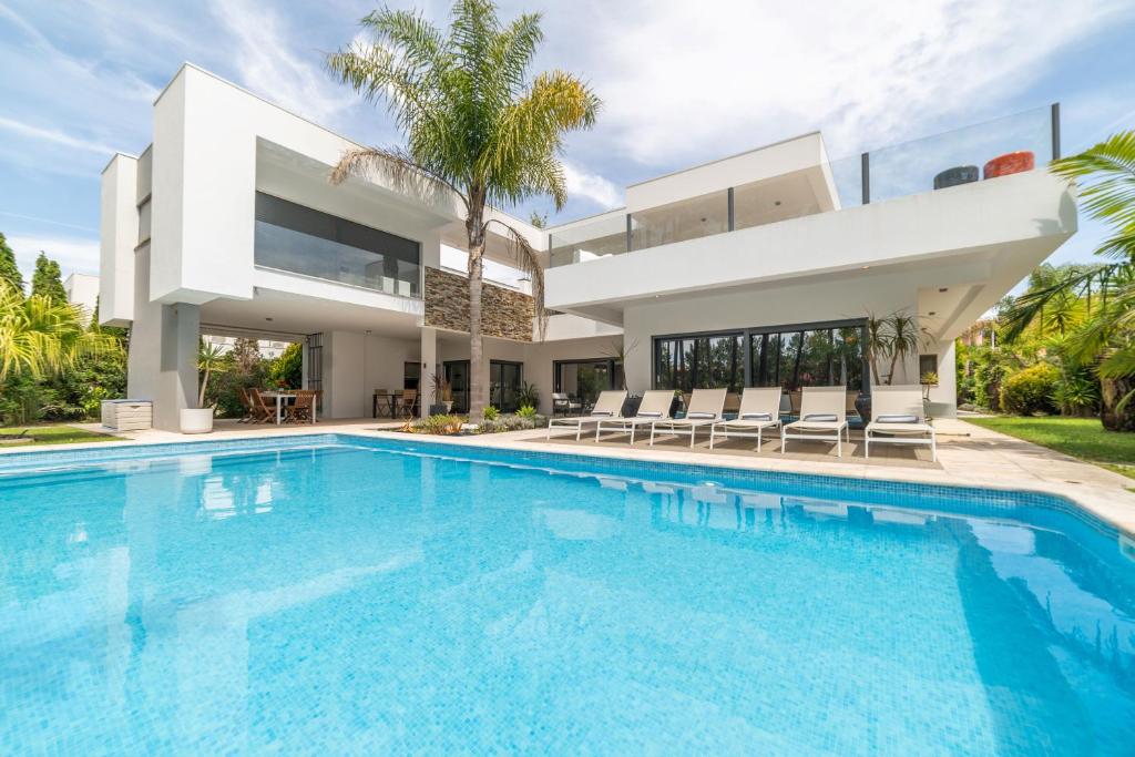 uma grande piscina em frente a uma casa em Villa Mirage em Aroeira