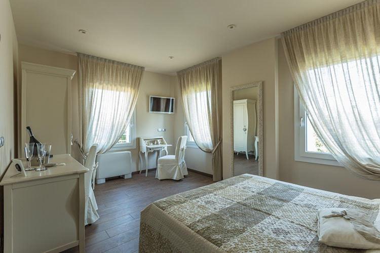 een slaapkamer met een bed en een tafel met stoelen bij Antica Dimora Stucky in Treviso