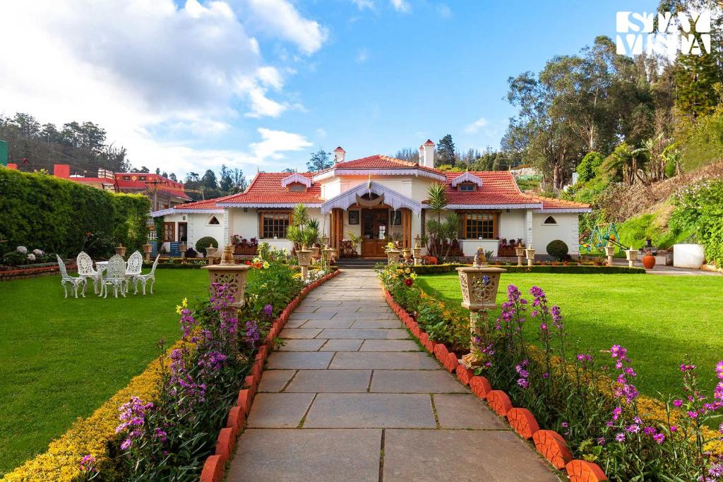 a house with a garden with purple flowers at StayVista at Greenwood Bungalow - Indoor & Outdoor Game in Ooty