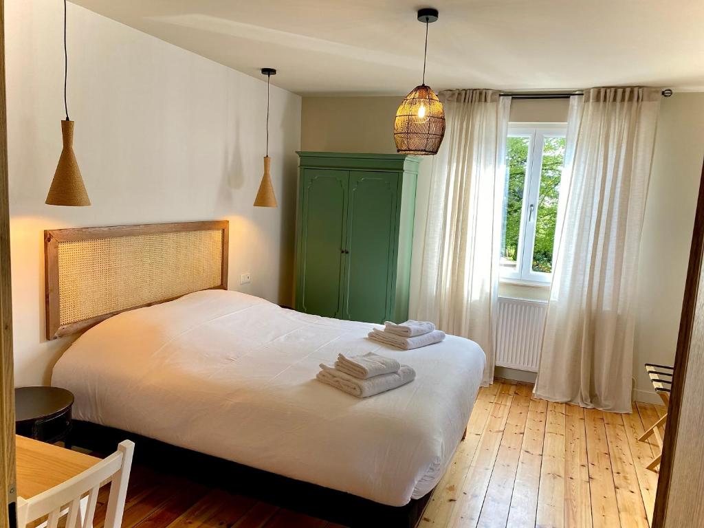 a bedroom with a white bed and a green cabinet at La Maison d'Irmine in Sarralbe