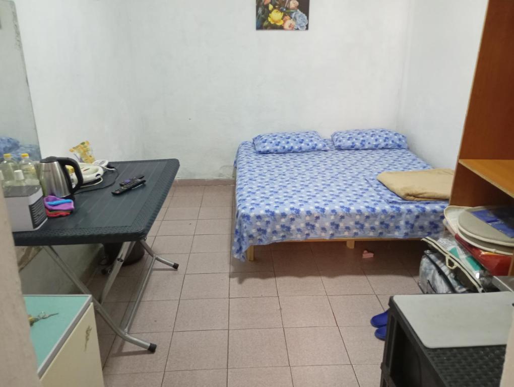 a small bedroom with a bed and a table at Private Studio 17 in Tirana
