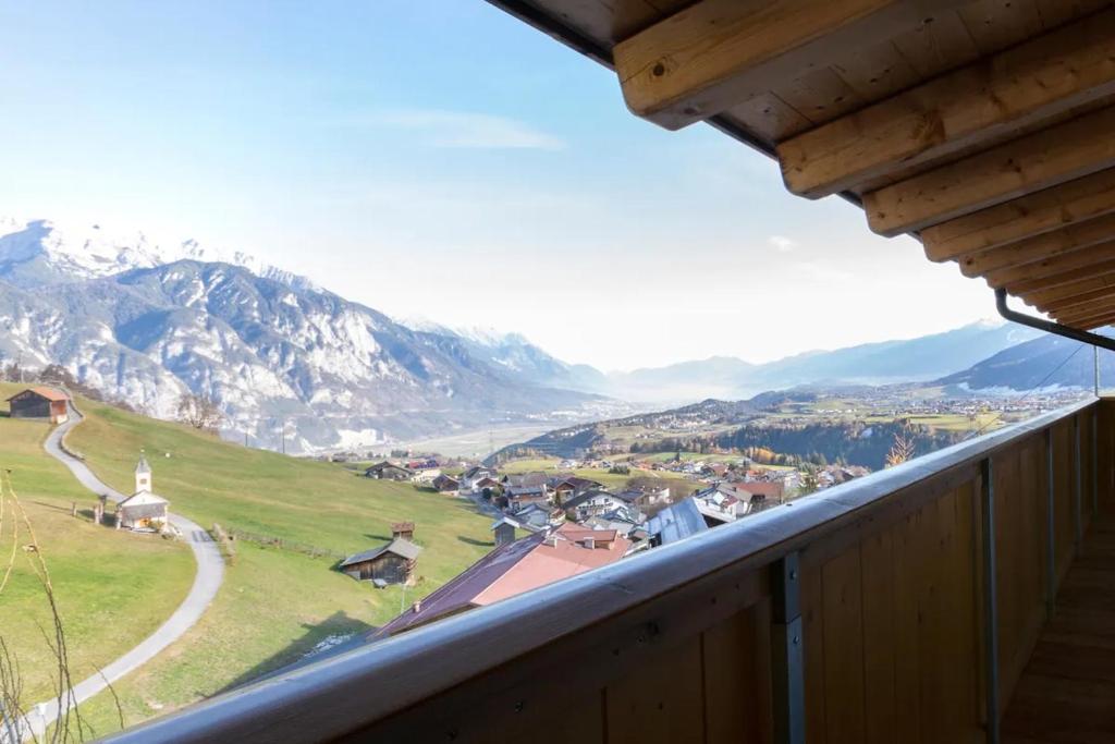 a view from a balcony of a town and mountains at Haus Sophia - Erholung mit Berg und Talblick in Oberperfuss