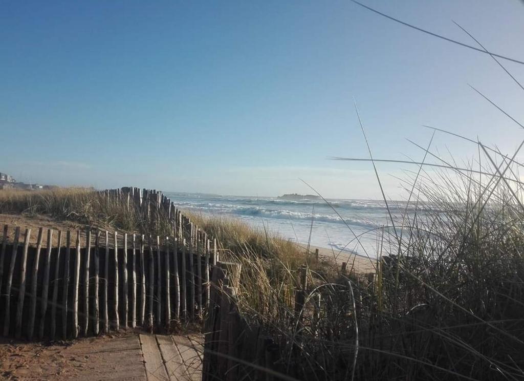 une clôture à côté d'une plage donnant sur l'océan dans l'établissement Maison de vacances à 5 min des plages, à Ploemeur