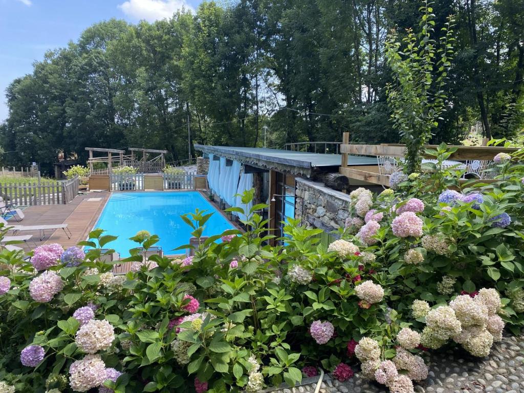 um jardim com flores e uma piscina em Il Sogno Della Vita AgriResort - Country Rooms & Suites em Peveragno