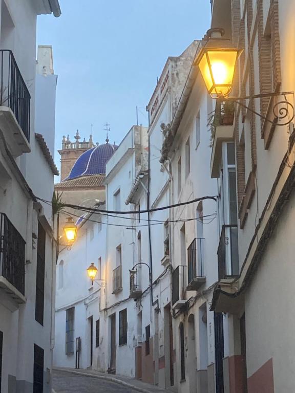 an alley with white buildings and street lights at Cute and characterful townhouse in Oliva