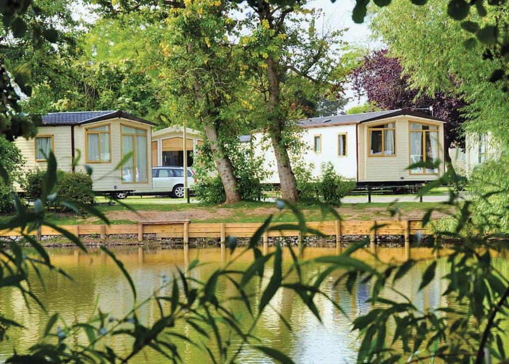um par de casas móveis estacionadas ao lado de um lago em Lakeside Holiday Park em Burnham on Sea
