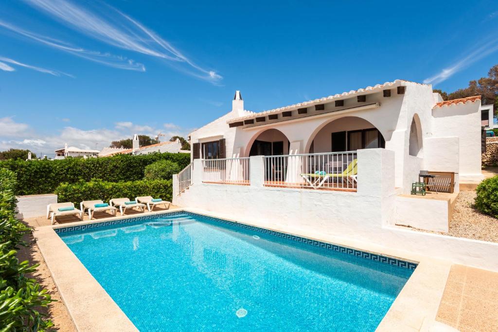a villa with a swimming pool and a house at Bini Luna - Binibeca Vell in Binibeca