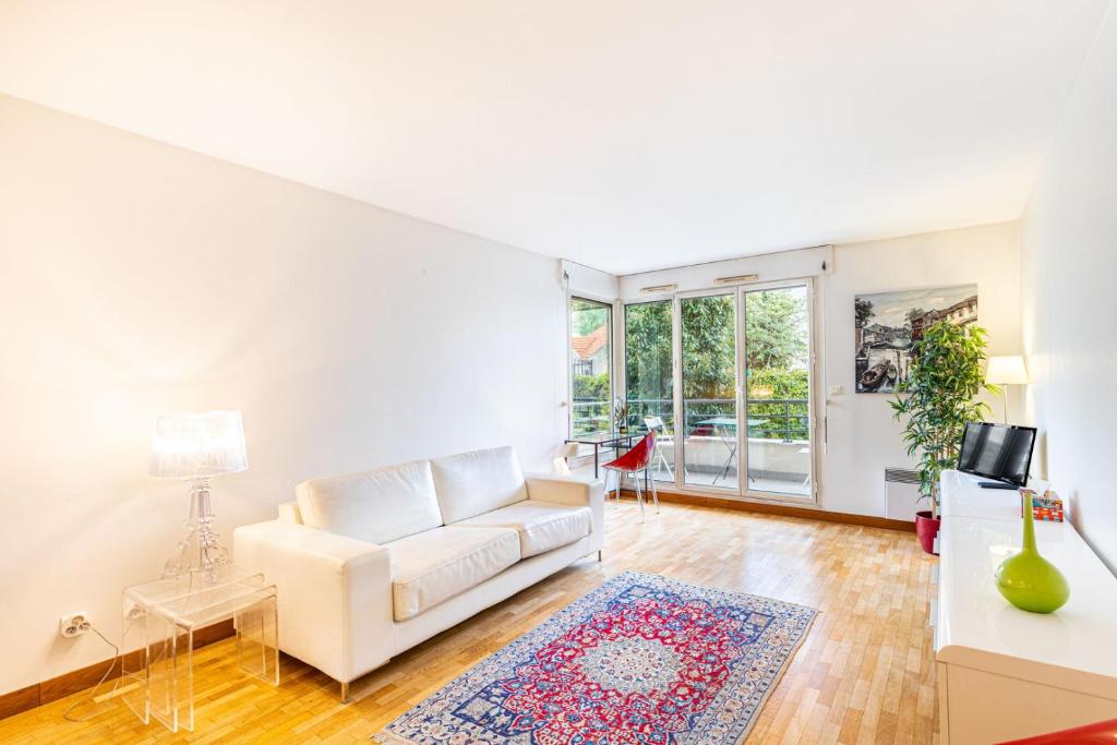 un soggiorno con divano bianco e tappeto di GuestReady - Era uma vez em Montparnasse a Parigi