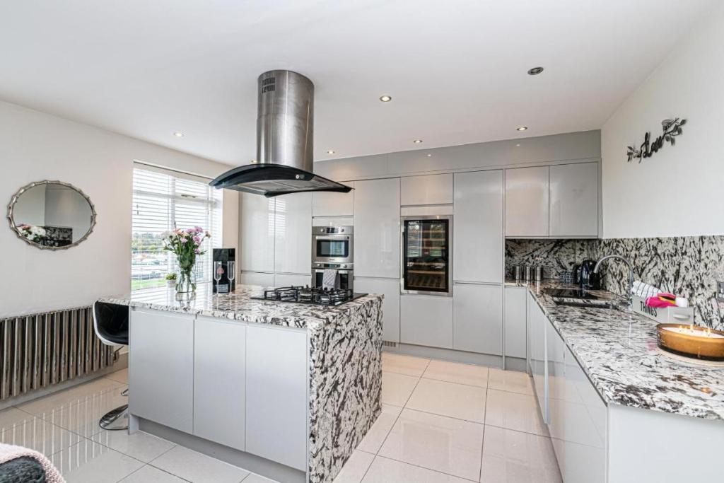 a kitchen with white cabinets and marble counter tops at The POPULAR Chester Racecourse Apartments, Duplex, Sleeps 4, FREE Parking in Hough Green