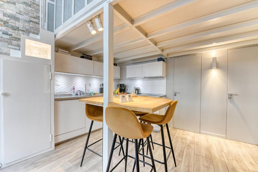 a kitchen with a wooden table and chairs at GuestReady - Stonewall Mezzanine in Brotteaux in Lyon