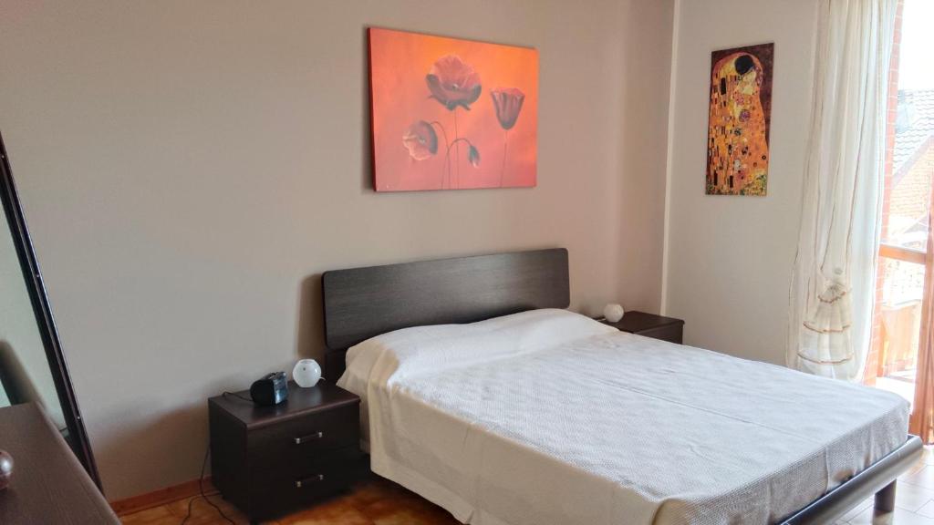 a bedroom with a bed and a painting on the wall at Appartamento Laura in Quargnento
