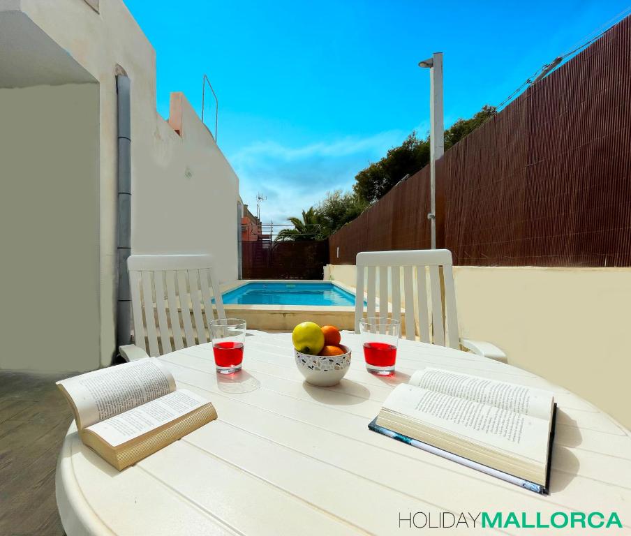 een witte tafel met een fruitschaal en een boek bij Lakeside Plaza - Alcúdia Beach in Alcudia