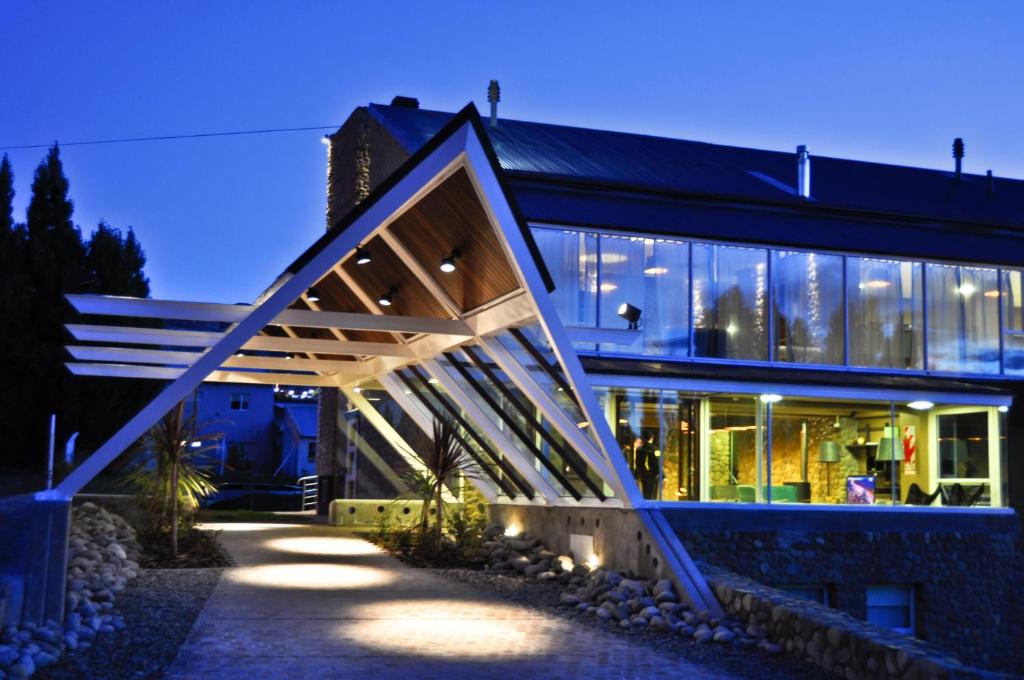 a house with a large wooden structure at night at Hotel ACA El Calafate in El Calafate