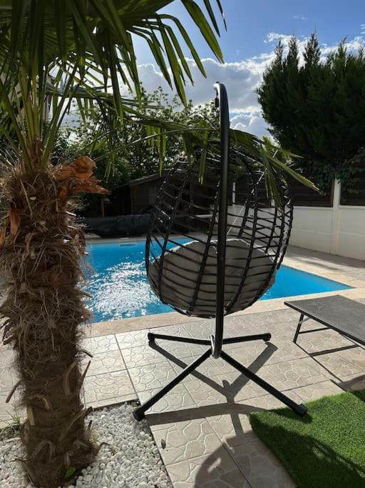 une chaise assise à côté d'une piscine dans l'établissement Charmante maison au Nord de Paris piscine chauffée, à Argenteuil