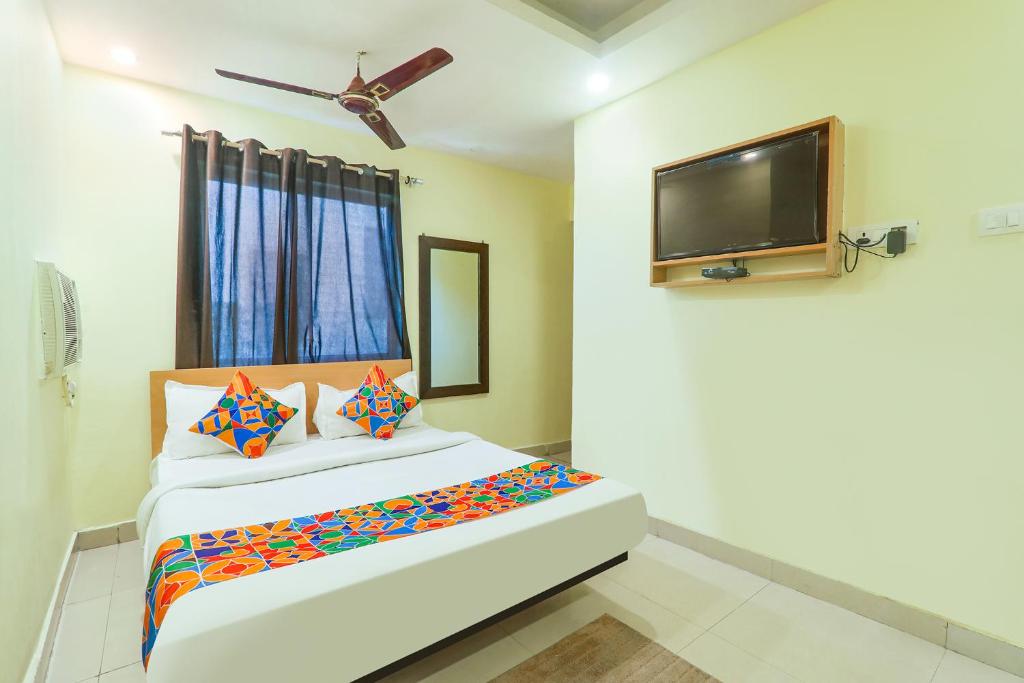 a bedroom with a bed and a flat screen tv at FabHotel Magadh Regency in Patna