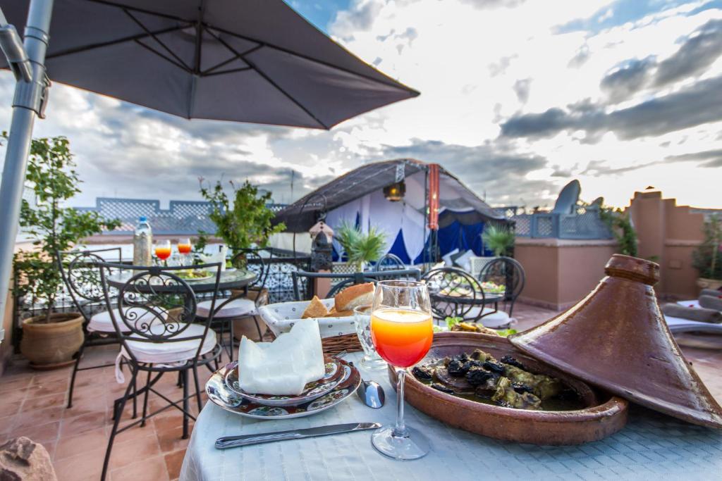 einen Tisch mit einem Teller Essen und einem Glas Orangensaft in der Unterkunft Riad Dar Azul in Marrakesch