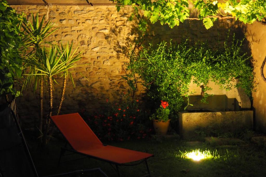 einen Garten mit einem Stuhl und Pflanzen in der Nacht in der Unterkunft Chambres d'Hôtes Le relais des marmottes in Lagnes