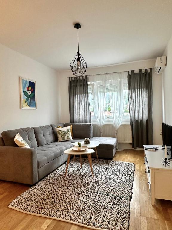 a living room with a couch and a table at City Break Apartment in Visoko