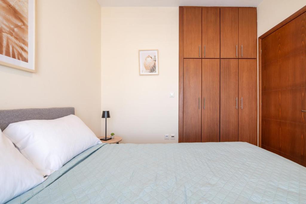 - une chambre avec un grand lit et une armoire en bois dans l'établissement Kyma 3 - 5 min to Beach, à Kos