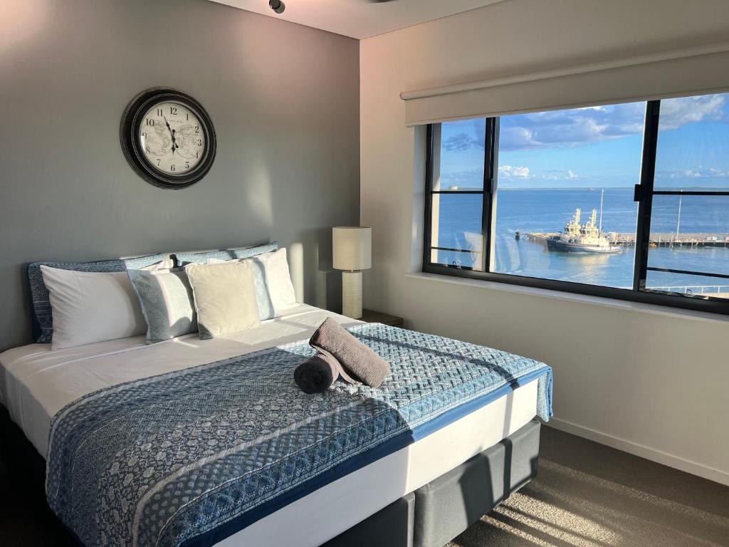 1 dormitorio con ventana grande con reloj en la pared en Sea Renity at Waterfront - SEAVIEW en Darwin